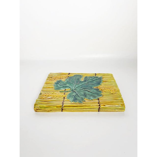 Decorative French glazed ceramic trivet dating from the 1970s, featuring a richly textured design inspired by nature. The...