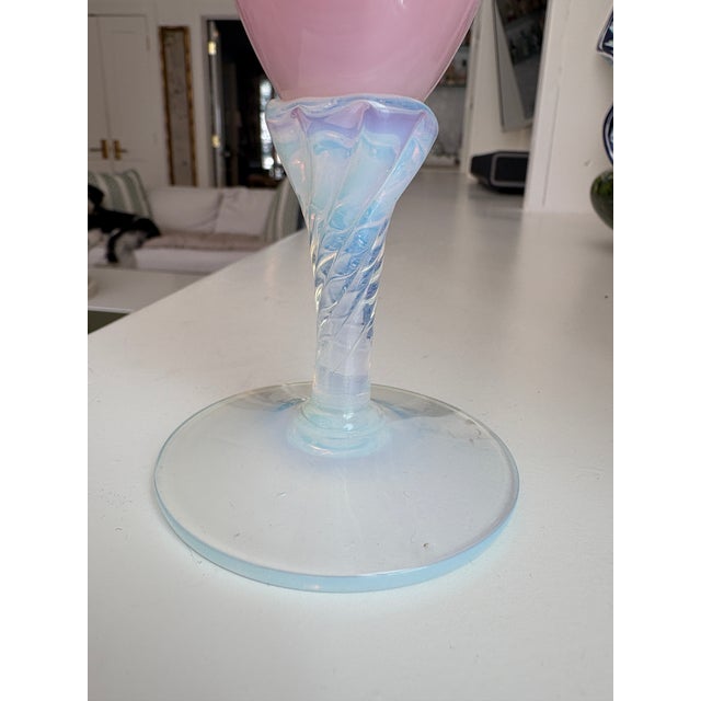 A dreamy mid-century opaline glass bud vase in soft ballet pink. It has a slender, elongated teardrop body that rises to a...