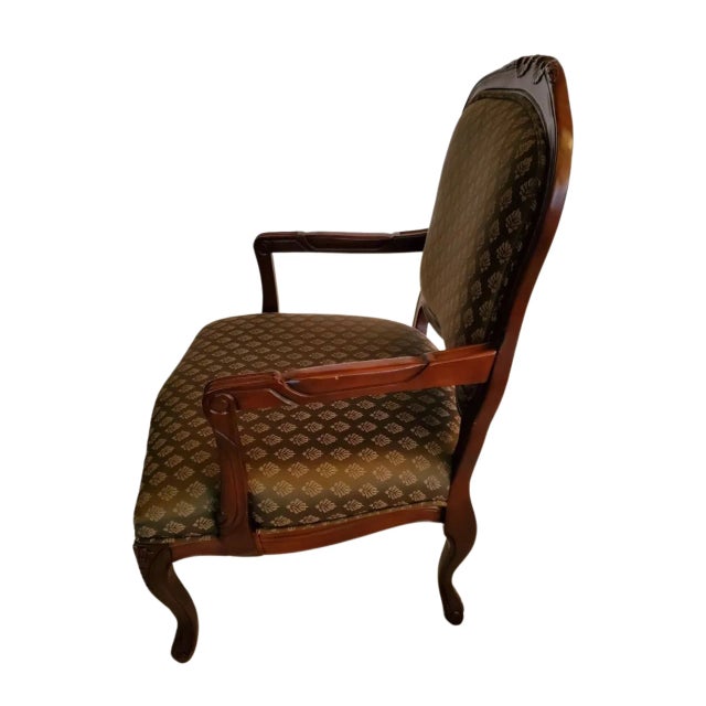 Beautiful side chair by the Baker Furniture Company. Green fabric with gold design covering with hand-carved mahogany...