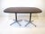 A dark walnut topped smaller scale dining table with black rubber edge trim sitting on double pedestal star base ....