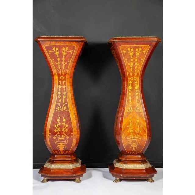 This elegant pair of French 19th century marquetry inlaid pedestals with a green marble top, base with finely carved...