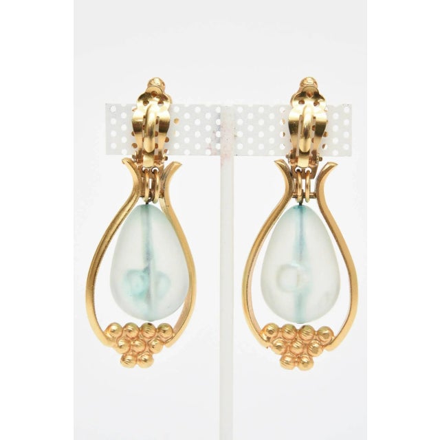 This is part of Chairish’s Costume Jewelry assortment. This pair of lovely 1980's clip on earrings are gold plated with a...