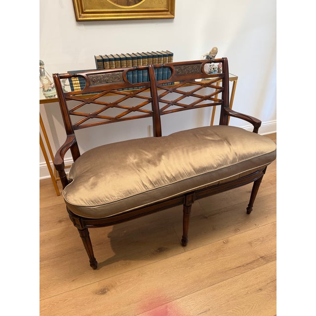 Elegant vintage mahogany settee featuring an exceptionally handsome open diamond-lattice back, carved decorative crest...