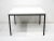 A early production T Angle side table with satin black steel base and white Laminate top designed by Florence Knoll . The...