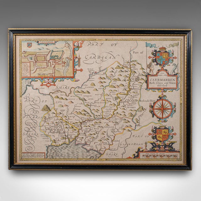 This is an antique map of Carmarthenshire. An English, framed county and town map by John Speed with dual sided atlas...