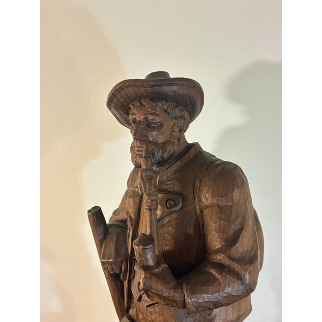 A finely hand-carved antique Black Forest figure depicting a bearded hunter accompanied by his loyal dog. Rich with...