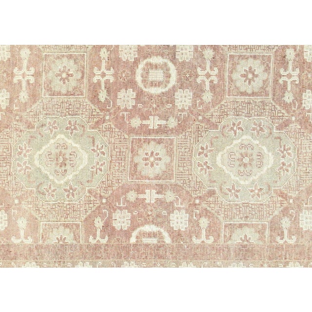 This vintage Khotan rug originates from Fustat, the ancient capital of Egypt near Cairo, where master weavers crafted it...