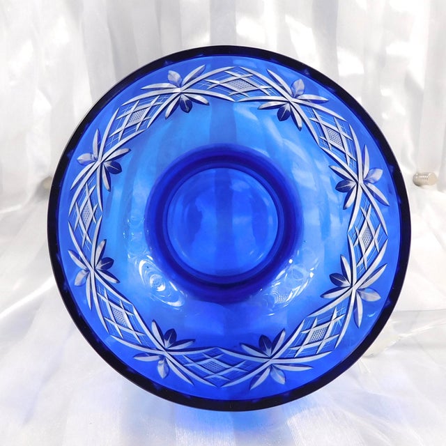 This is a footed blue cut to clear vase or bowl in an interesting shape. It looks like a large juice glass and only the...
