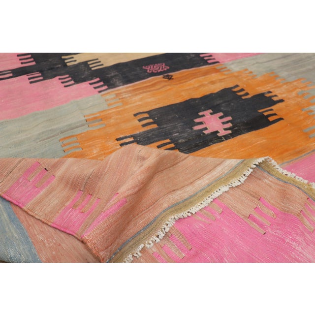 A room size Turkish Kilim from the mid-20th century highlighted in bright pink & orange shades Measures: 7' x 10'2".
