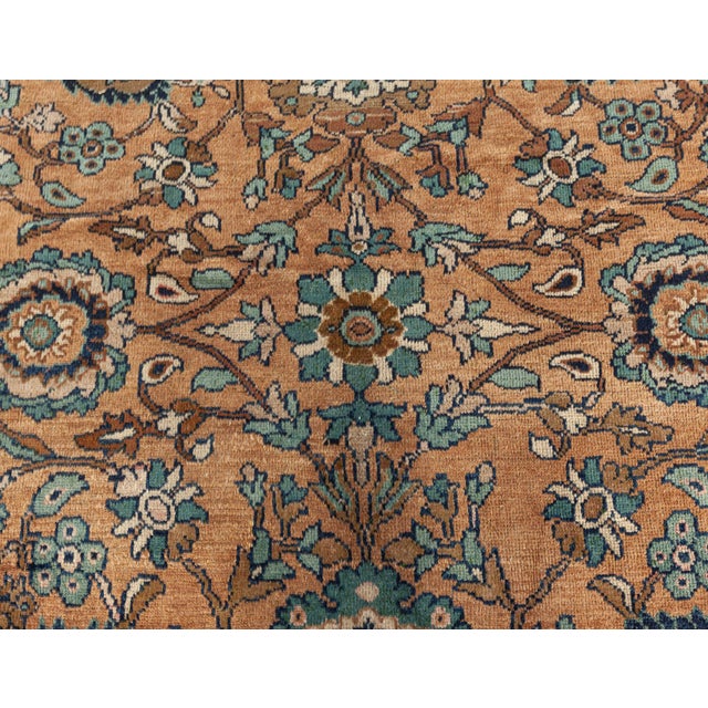 A hand-knotted wool antique Persian Sultanabad size adjusted rug dating back to circa 1920. The main field features an...