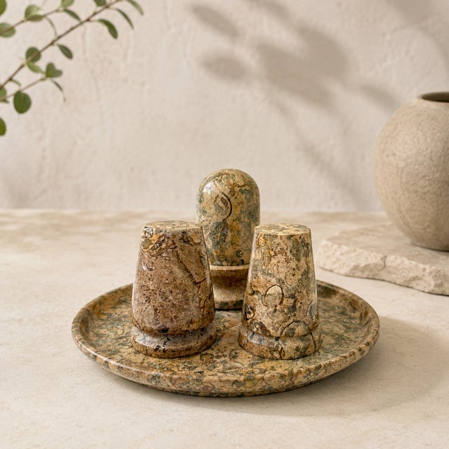 A striking vintage condiment set carved from fossil coral marble, showcasing naturally preserved marine fossils embedded...