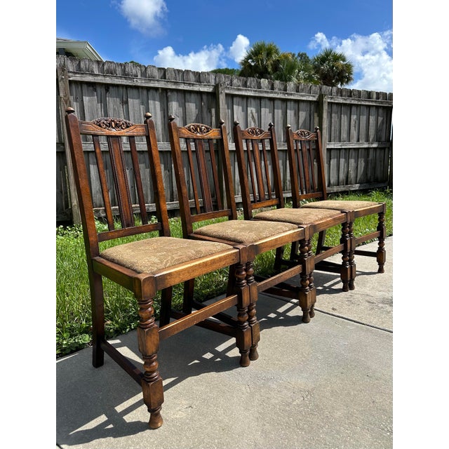 Antique carved oak side chairs in a Jacobean Revival or Arts & Crafts style. High slatted back with carved top crest,...