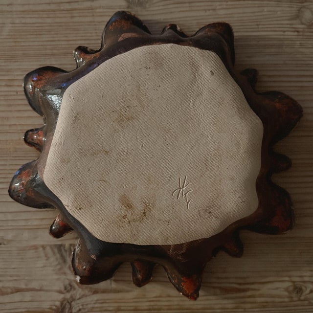 A striking vintage studio pottery bowl featuring an expressive freeform silhouette and richly layered volcanic glaze in...