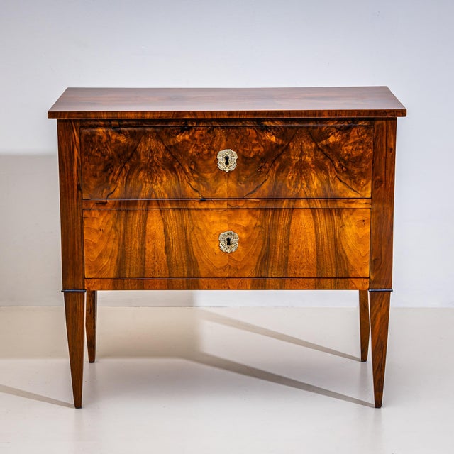 Small Biedermeier chest of drawers raised on tapered square legs, with two drawers and bronze mounts. Veneered in walnut...