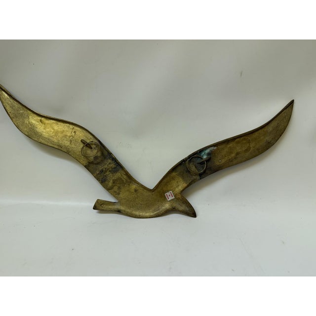 Bring an elegant touch of 1970s coastal modernism to your space with this striking vintage brass seagull wall sculpture....