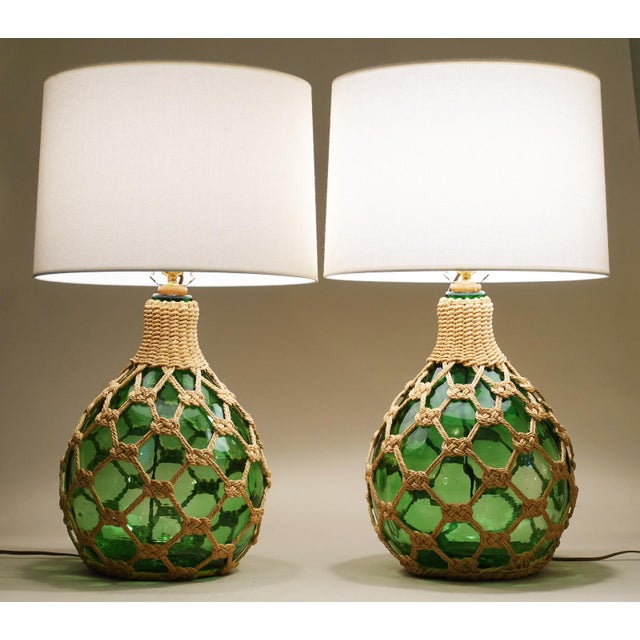 A brilliant and striking pair of large robust round bottle form "Macrame" net globes of bottle Green thick molded glass...