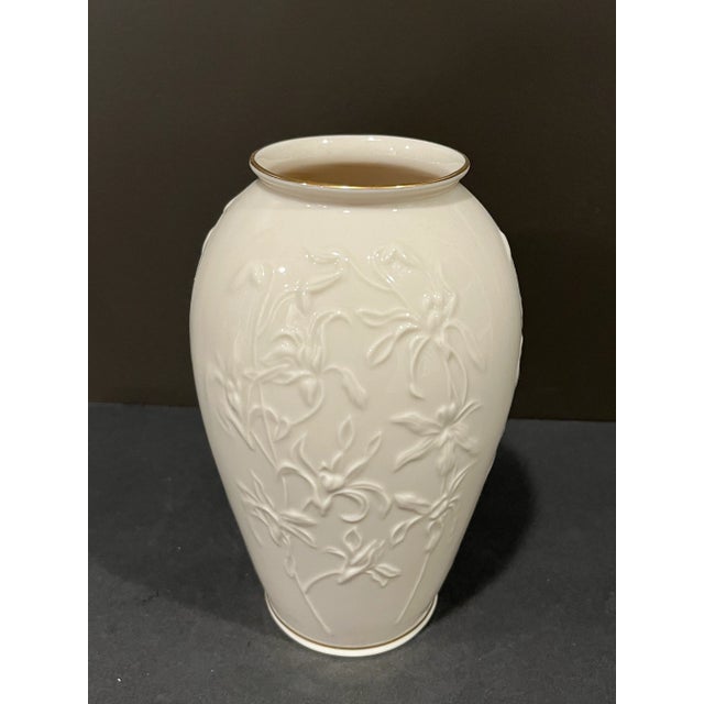 Vintage ivory vase with and raised iris design on two sides and 24 karat gold accents around the top and the base. The...