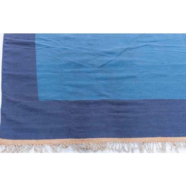 This refined 1955 Indian Dhurrie rug embodies the elegant simplicity and practical beauty that define mid-century Indian...