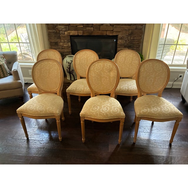 Elegant set of six Harris Marcus Furniture dining chairs featuring classic Louis XVI-style oval backs with carved wood...