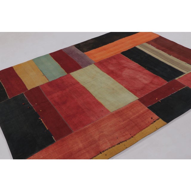 Handwoven in wool and cotton, this 6x8 vintage patchwork rug, circa 1950-1960, is a striking example of Turkish textile...