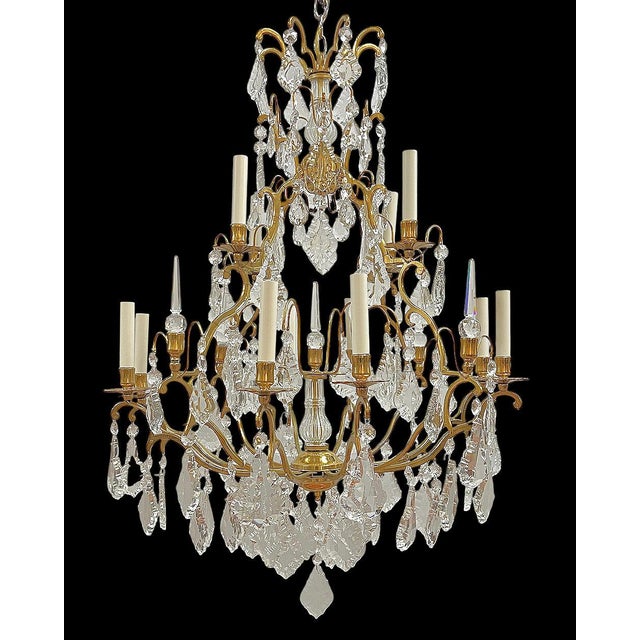 Fine gilt bronze chandelier in the French Louis XV style with 12 electrified candles and dozens of crystal glass pendants...