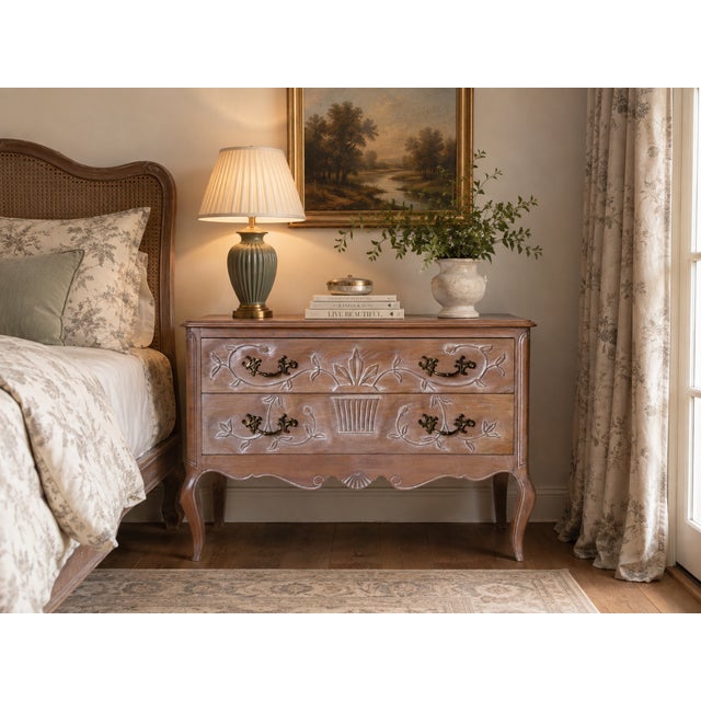 Charming vintage French Provincial style wooden nightstand featuring two spacious drawers with carved floral. The warm...
