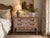 Charming vintage French Provincial style wooden nightstand featuring two spacious drawers with carved floral. The warm...