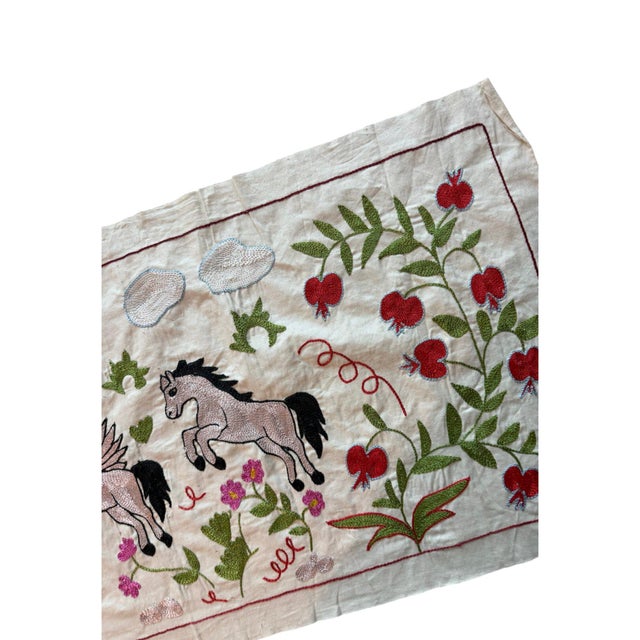 Hand-embroidered Suzani panel from Uzbekistan, worked in fine floss on a cream cotton ground. Two winged horses and two...
