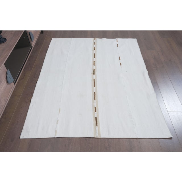 Elevate your space with this authentic 1970s vintage handwoven flatweave rug. Crafted from a blend of natural hand-spun...