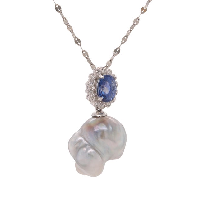 Platinum pendant with sapphire, diamond halo, and baroque South Sea pearl. A graceful design blending organic form with...
