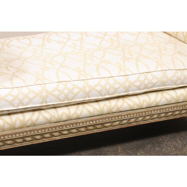 A French Récamier style carved-wood daybed from the early 20th century. This antique backless sofa bench from France is...