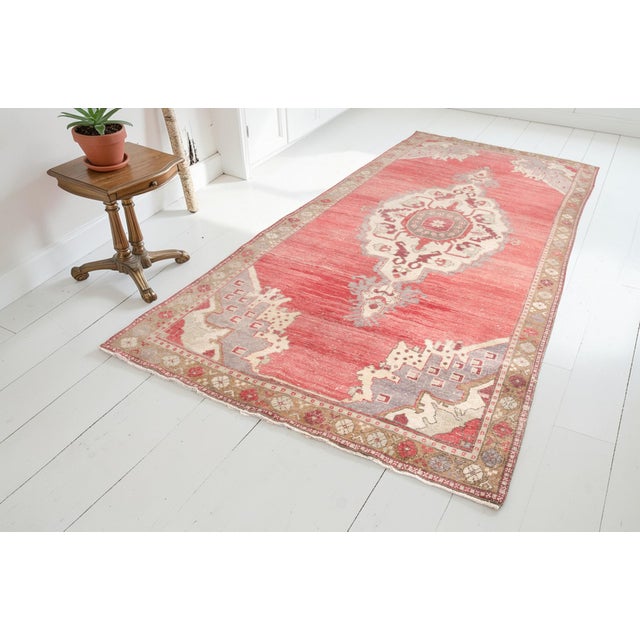 This is a vintage Turkish Oushak rug from the Mid 20th Century. The piece was hand-knotted.