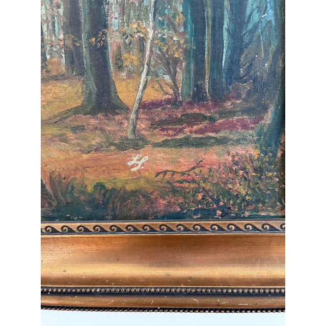 This signed antique original landscape oil painting, from around 1910, shows a forest landscape with a narrow stream...