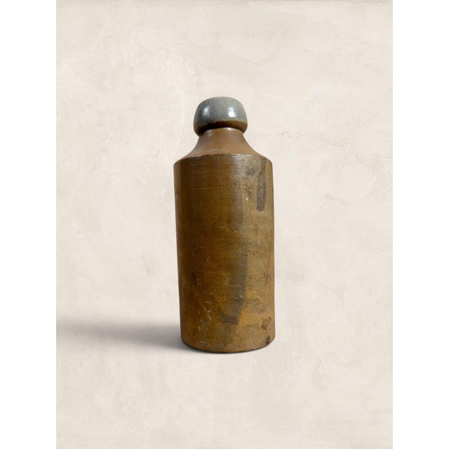 A charming late 19th to early 20th century English stoneware ginger beer bottle embossed "R. White" with the maker's mark...