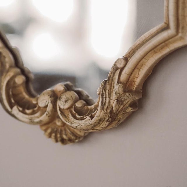 Wall mirror in a curved cartouche shape with a shell-shaped crown and rocaille ornamentation, designed in the rococo...