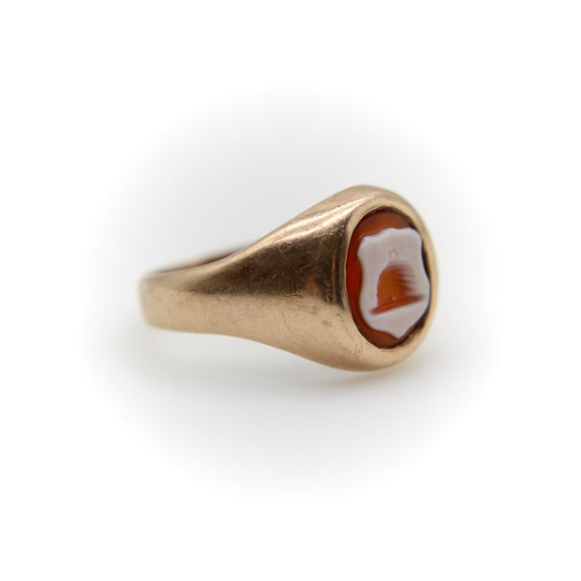 This simple and understated 9k gold intaglio ring has a tiny beehive carved into a banded agate shield on a carnelian...