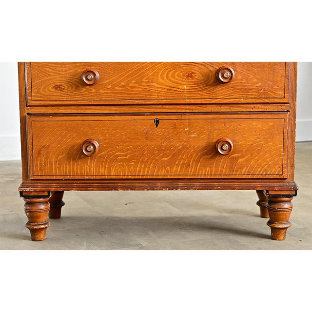 This English chest of drawers from the 19th Century is built from solid pine with a faux bois finish to imitate oak. The...