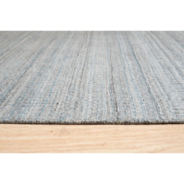 Para Elena Blue Handmade Wool Rug, Country of Origin: India. This piece exemplifies the refined simplicity characteristic...