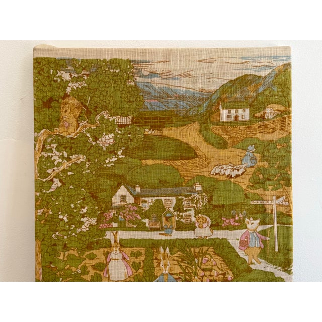 Delightful linen panel of the Land of Beatrix Potter, displayed on a wood frame. Features characters and locales across...