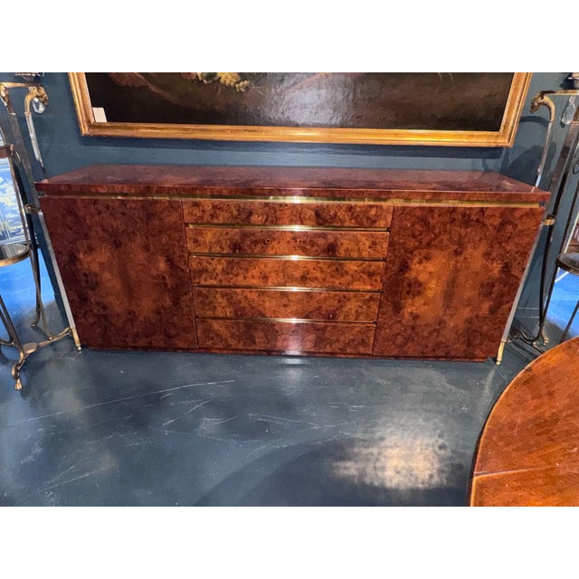 Elegant MCM sideboard crafted in rich burl walnut, accented with refined brass hardware. Designed with clean lines for...