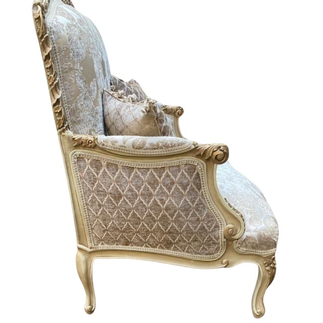 Beautiful sofa with gold angels details on the sides and a beige color on the upholstery with a gold detail in the middle...