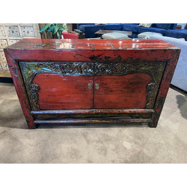 This striking Asian-style lacquered wood console table showcases rich red lacquer with dramatic black undertones and hand-...