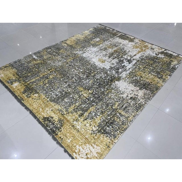 This hand knotted pile rug is crafted from wool and features a primary color palette of ivory, beige, cream, and white. It...