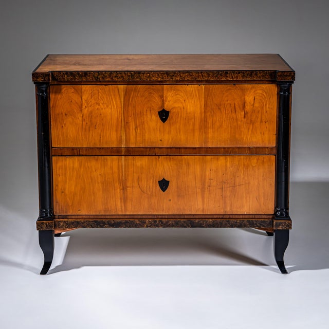 Biedermeier chest of drawers featuring two drawers, crafted in cherry wood with expressive burl veneer and contrasting...