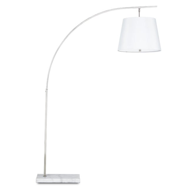 The angular arc of the stem of the Cloister Nickel Floor Lamp, the way the shade dangles, and the minimal shape of its...