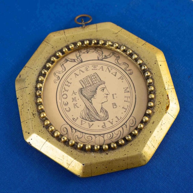 Captivating vintage portrait showcasing an ancient Alexandrian coin, framed in a luxurious round setting with an ornate...