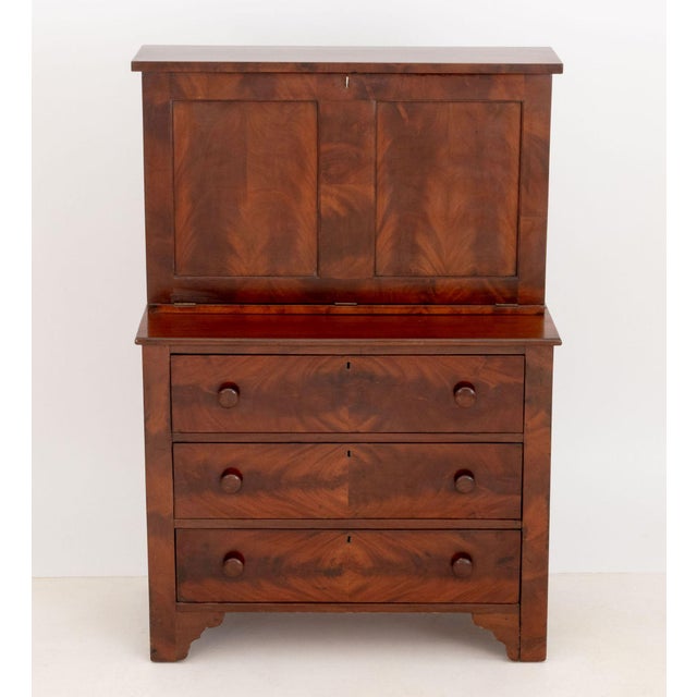 American Empire Style Flame Mahogany Secretary, the fall-front top opening to green felt writing surface opposite nine...