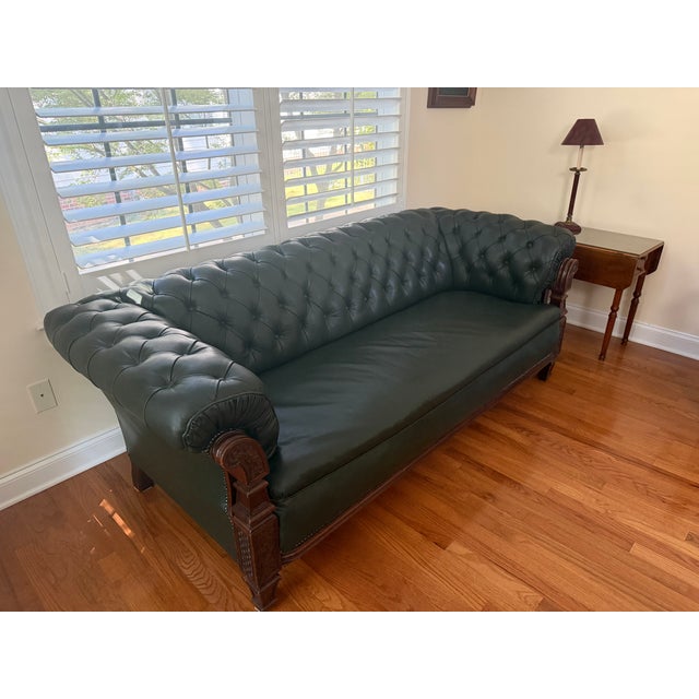 This dark green leather and walnut Chesterfield sofa is from the late 19th century. It has a tufted rectangular back and...