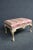 Louis XV style footstool featuring a carved and painted frame with claw and ball feet, floral carvings, and a generously...