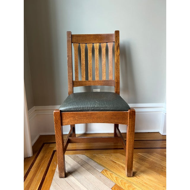 A lovely set of six Stickley oak cottage dining chairs with upholstered dark green leather seats. Purchased directly from...
